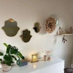 Miroirs marocains faits main avec bords dorés en forme de main de Fatima accrochés au mur à côté d'autres décorations