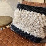 Housse de coussin kesh marocaine tissée à la main en noir et blanc posée sur une chaise