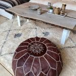 Brauner Lederpouf mit Stickmuster in Weiß in einem Wohnzimmer
