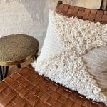 Housse de coussin kesh marocaine tissée à la main à motif blanc posée sur une chaise
