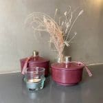 Maroquin bas rond noir Maroquin bas rond bordeaux avec autres décorations à côté de pots en stuc faits main à pompons roses pots en stuc faits main à pompons bleus