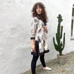 Modèle en tunique marocaine tissée à la main en beige avec motif de feuilles noires avec à côté de cactus
