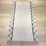 Hvidt marokkansk Beni Ouarain uldtæppe med pyramide mønster i sort på siderne