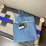 Serviette de hammam marocaine tissée à la main en bleu avec un pain de savon sur le dessus, sur un banc