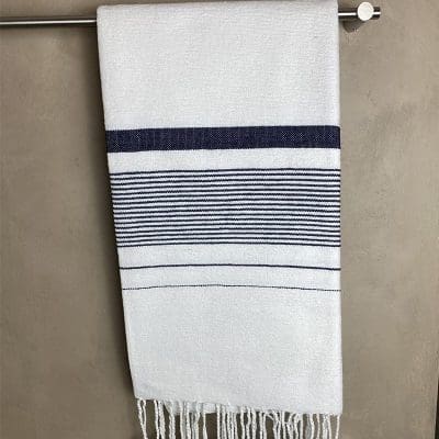 Weißes marokkanisches handgefertigtes Hamamtuch mit schwarzen Streifen, das in einem Badezimmer hängt