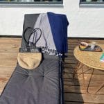 Marockansk handvävd hamamhandduk med blått marockanskt mönster hängande på en solsäng med andra marockanska produkter bredvid