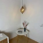 Marokkansk håndlaget, svingende, dråpeformet lampe hengende over et dekorasjonsbord
