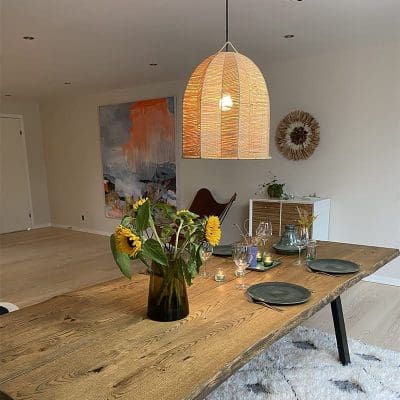 Marokkaanse handgemaakte raffialamp in stervormig vlechtwerk op een overdekte eettafel