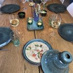Vier marokkanische Teller und eine Tajine-Schale aus grünem Marmor auf einem Esstisch