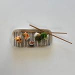 Marockanskt fat i vitt med svart prickmönster med sushi på toppen