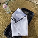 Serviettes en tissu blanc avec motif marocain brodé à la main sur une assiette avec décorations sur le côté