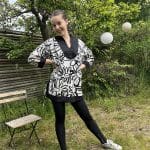 Model in Moroccan handwoven tunic in white with black floral pattern