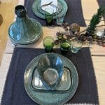 Sets de table marocains brodés à la main sur une table finement dressée, remplie de plats en grès et de verres beldi