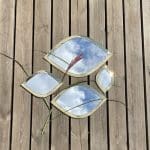 Four Moroccan hand-made eyelid-shaped mirrors with gold trim, in different size variants, lying side by side, with decorations around