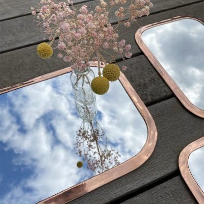 Tre rektangulære marokkanske håndlavede spejle med afrundede kanter af rose gold metal i forskellige varianter, med blomsterdekorationer rundt om, tæt