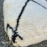 Quadratisches marokkanisches handgenähtes Bodenkissen aus Wolle mit großem schwarzem Kreuzmotiv, dicht