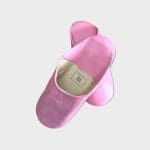 Chaussons marocains faits à la main en rose, où une chaussure est sur l'autre