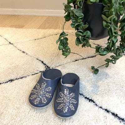 Chaussons marocains faits main en gris avec paillettes sur tapis Beni Ouarain