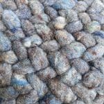 Round Moroccan hand-sewn wool pouf in petrol blue, dense