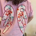 Angel Blush Shirt in Pink mit weißen Streifen und aufgenähten Engelsflügeln auf dem Rücken