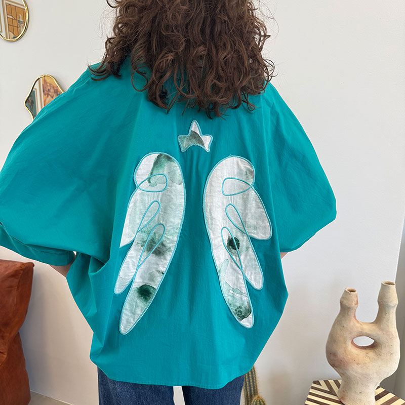 Skjorte_ANGEL-TIDE_5 Shirt ANGEL TIDE_ turquoise blue shirt with sewn-on angel wings on the back