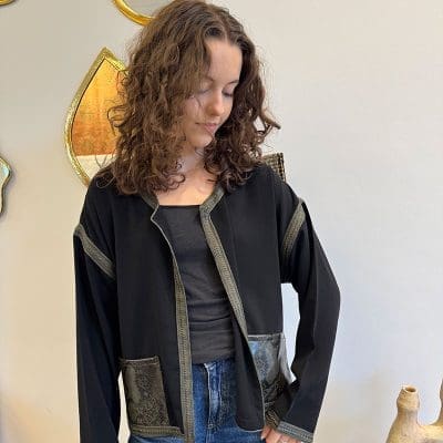 Gilet/veste_NOÍR SAUVAGE_en tissu noir doux avec bordure verte et poches en peau de serpent