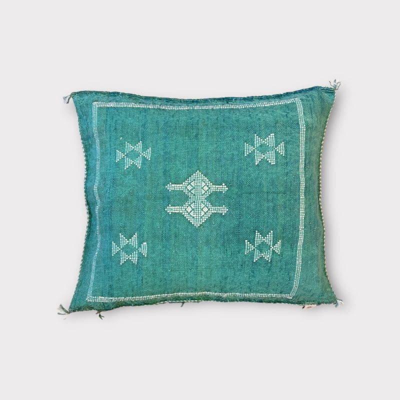 Green cactus silk pillowcase with bluish undertones. Turquoise hue. White stitching/patterns.
