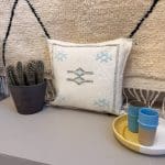 Witte kussensloop, handgemaakt in Marokko van cactuszijde. Met blauwe stiksels/patroon.