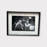 Zwart-witfoto in horizontale stand van twee oudere heren die samen zitten te praten.