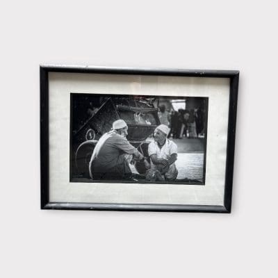 Zwart-witfoto in horizontale stand van twee oudere heren die samen zitten te praten.