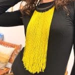 Collier de perles jaunes et collier noir tressé en cuir.