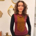 Collier composé de perles orange chaud et noires et d'un anneau de cou orange en cuir tressé.