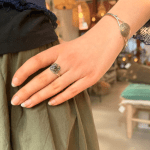 Silver ring with beautiful stone with unique, delicate silver carvings surrounding the black stone in the center.