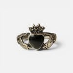Unieke ring met twee handen die een zwart hart met een kroon erop vasthouden.