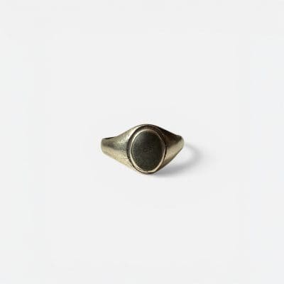 Eenvoudige zilveren ring met een zwarte steen in het midden.