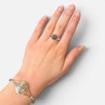 Bague simple en argent avec une pierre noire au centre.