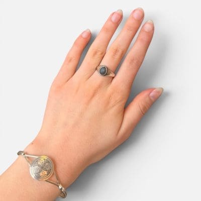 Eenvoudige zilveren ring met een zwarte steen in het midden.
